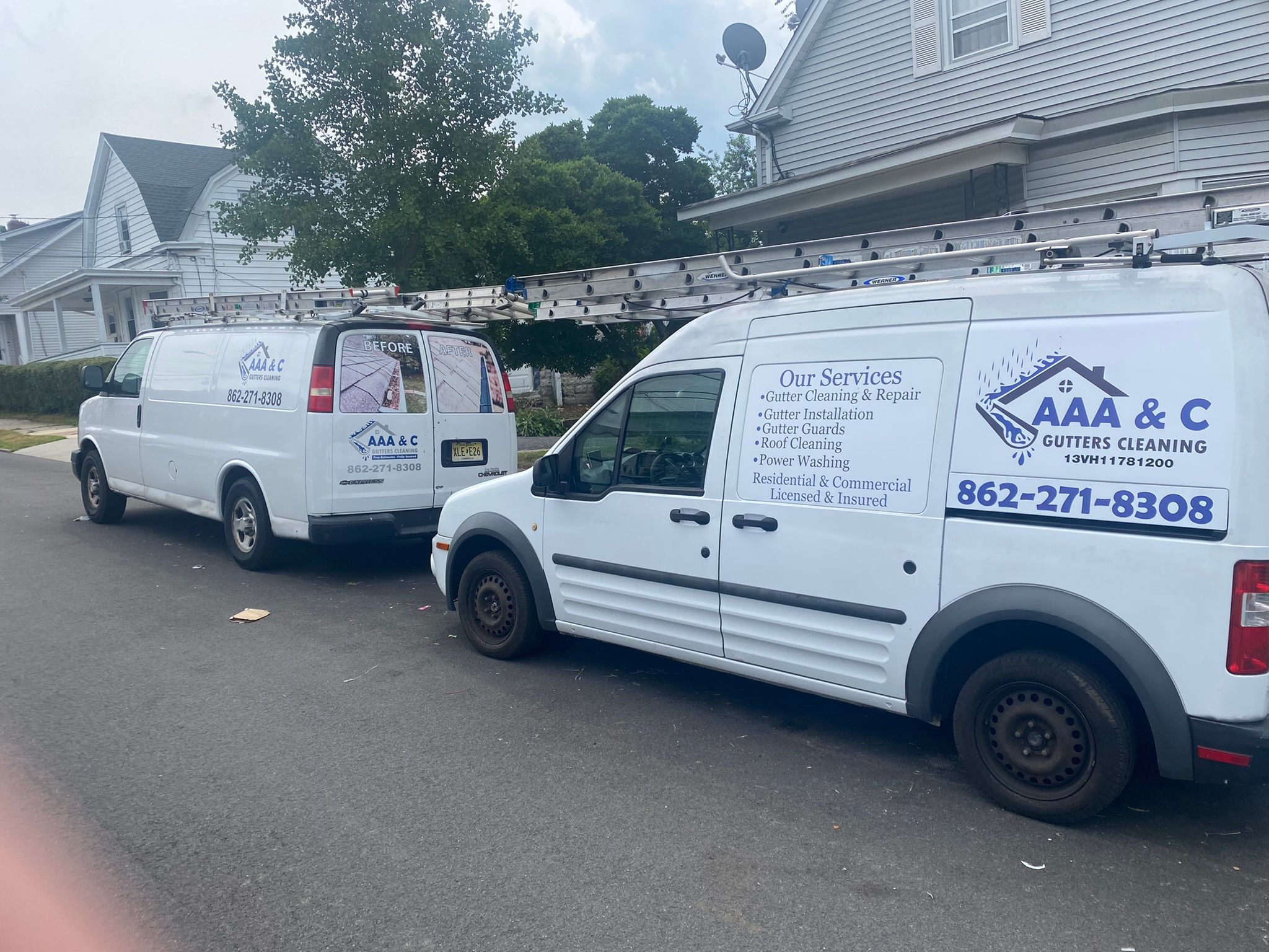 Two AAA & C Gutters Cleaning vans parked in front of a house